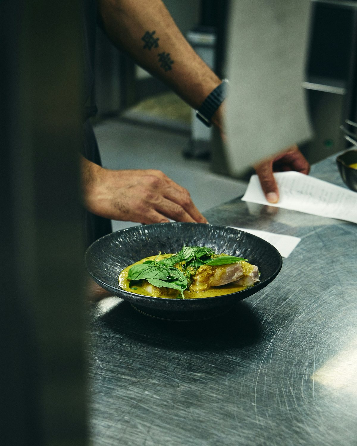 A chef plating a dish with a precise hand
