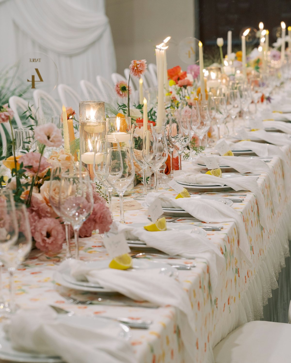 A long wedding table set and lit by candles